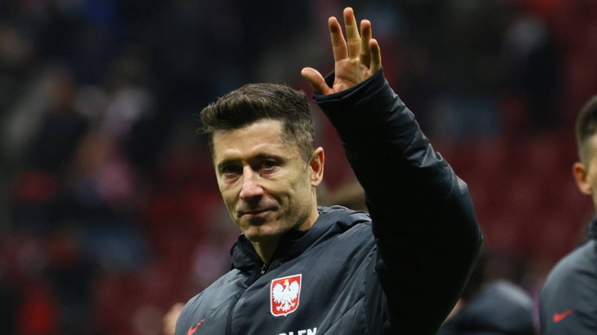 Robert Lewandowski w stroju reprezentacji Polski macha ręką do kibiców.