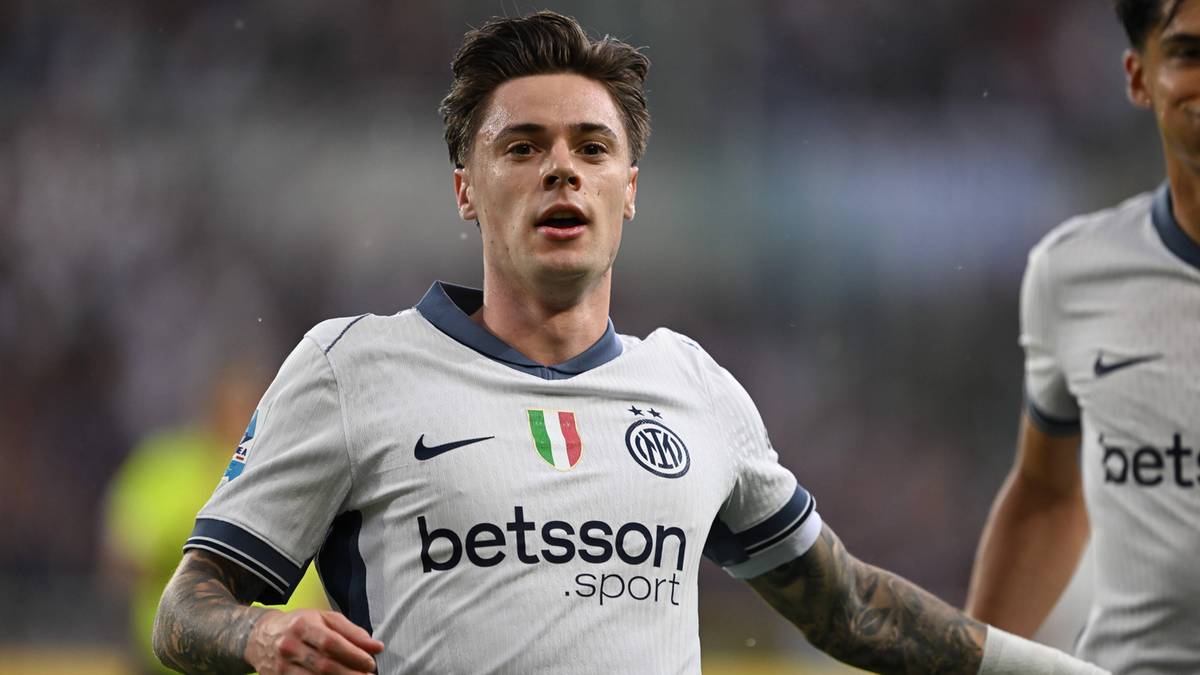 Portret mężczyzny w białej koszulce piłkarskiej z niebieskimi i ciemnogranatowymi detalami, z herbem klubu i napisem "betsson . sport". Ma ciemne, zaczesane do tyłu włosy i tatuaże na ramionach. Jest w trakcie meczu, a w tle widać innych piłkarzy i trybuny.