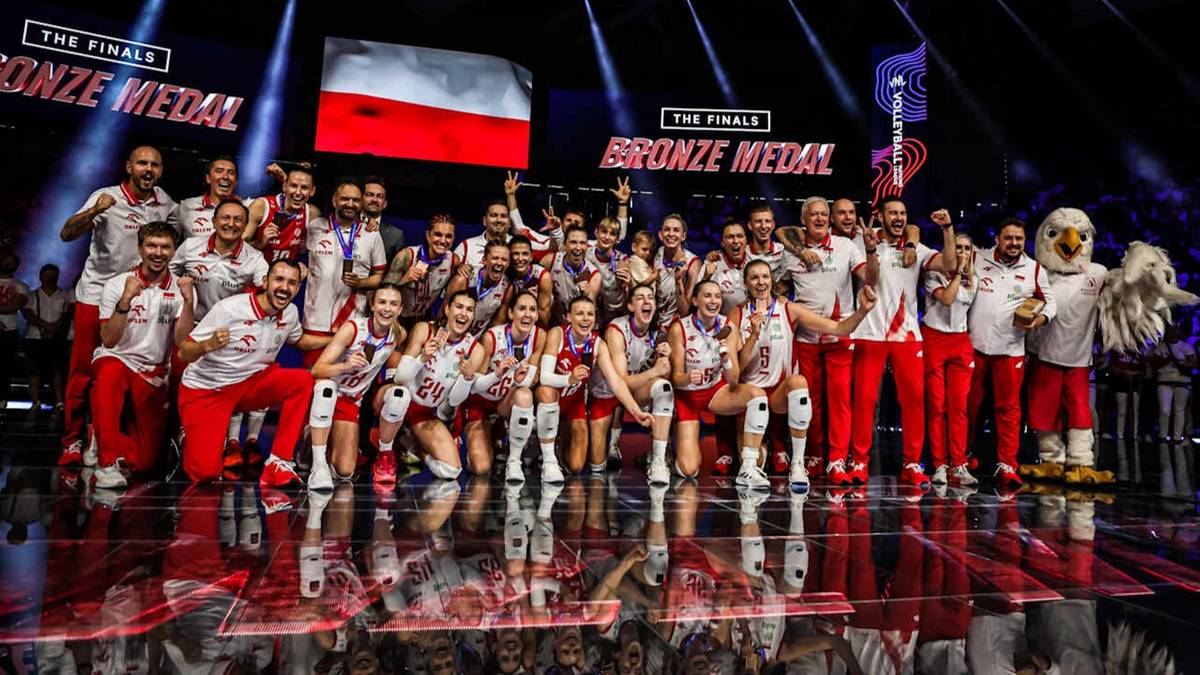Reprezentacja Polski w siatk&oacute;wce kobiet świętuje zdobycie brązowego medalu Ligi Narod&oacute;w, pozując do zdjęcia z flagą Polski i medalami na szyjach.