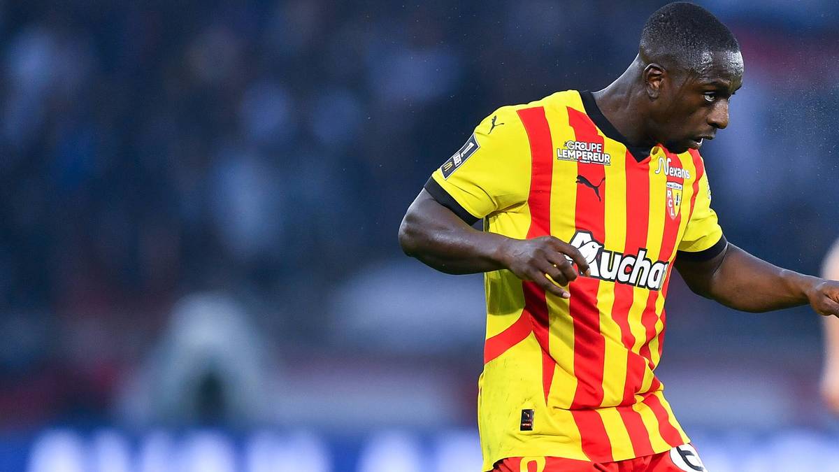 Piłkarz w ż&oacute;łto-czerwonej koszulce RC Lens wykonuje podanie.