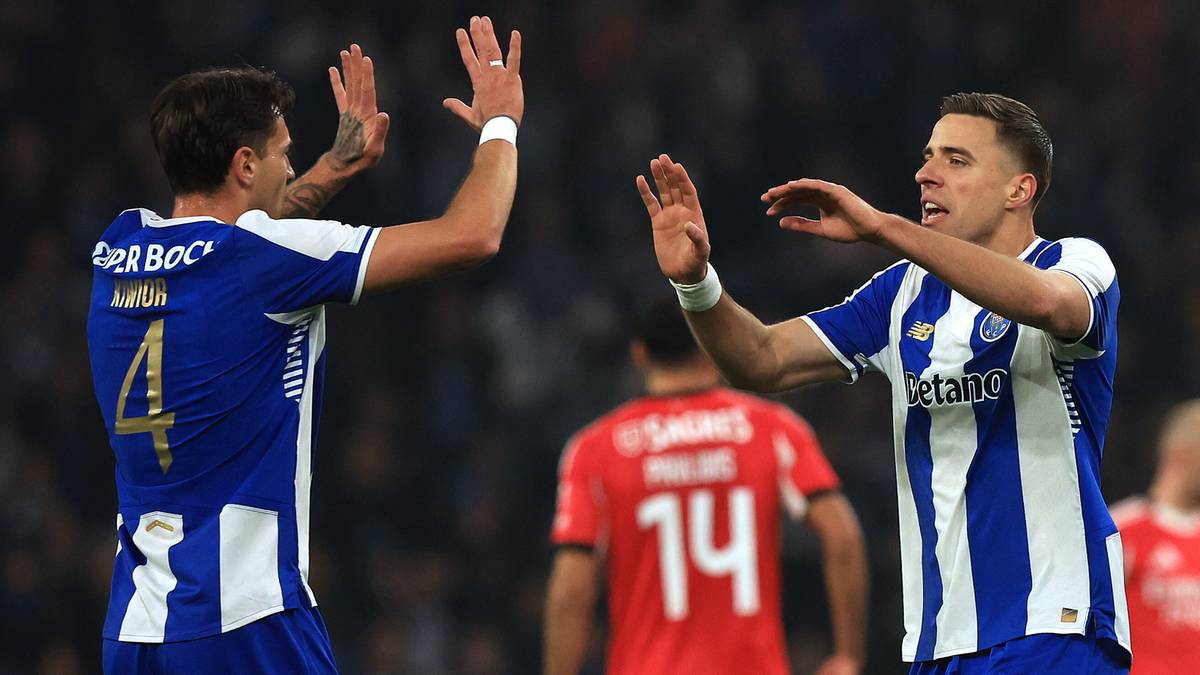 Dw&oacute;ch piłkarzy FC Porto w niebiesko-białych strojach świętuje zdobycie bramki, podając sobie ręce na znak radości.