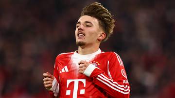 Portret młodego mężczyzny w czerwonej koszulce piłkarskiej Bayernu Monachium.