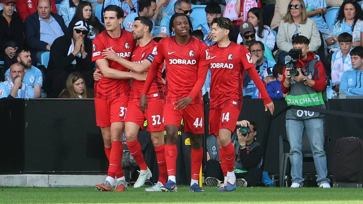 Piłkarze w czerwonych strojach świętują bramkę na stadionie.