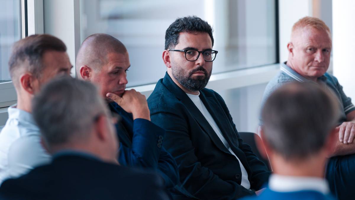 Grupa mężczyzn siedzących i rozmawiających podczas spotkania biznesowego.