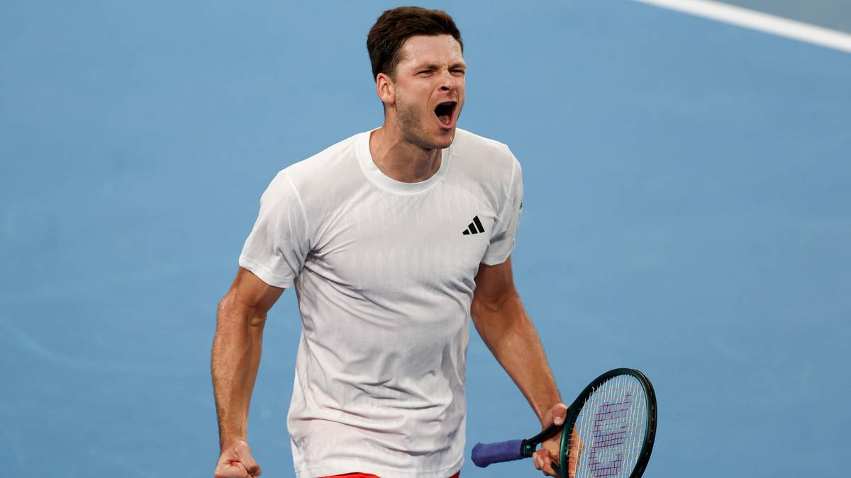 Tenisista cieszący się po zdobyciu punktu, trzymający rakietę.