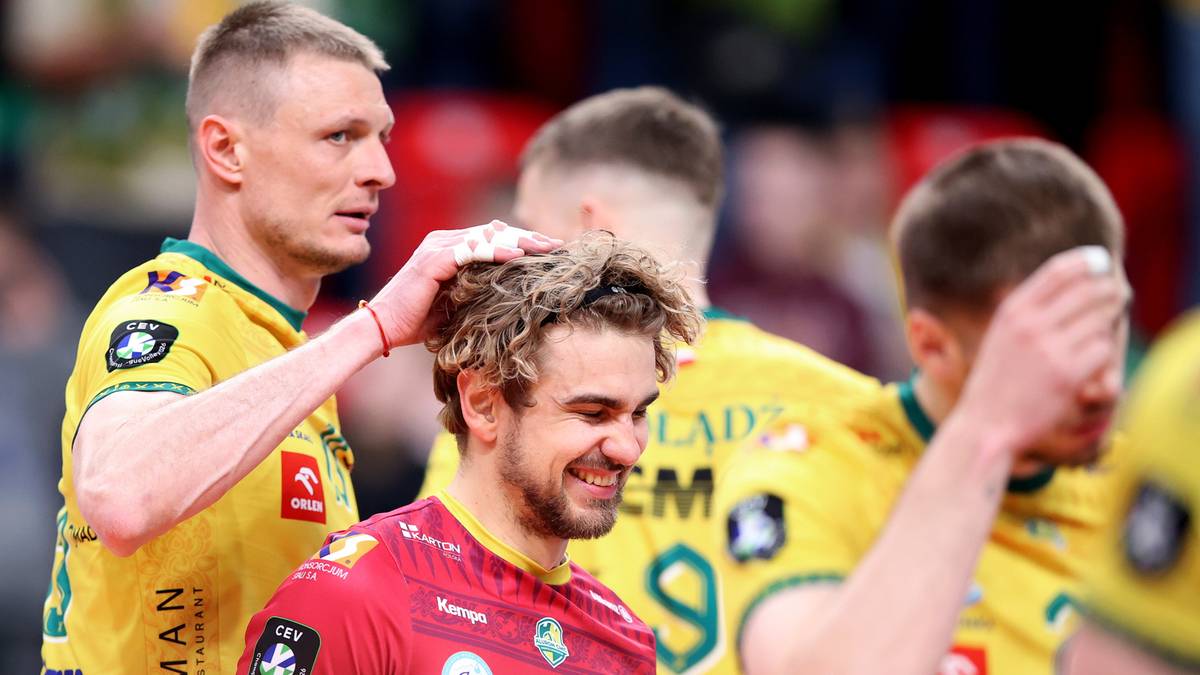 Dw&oacute;ch siatkarzy Aluronu CMC Warta Zawiercie w ż&oacute;łtych strojach dotyka głowy kolegi w czerwonej koszulce po wygranym meczu.