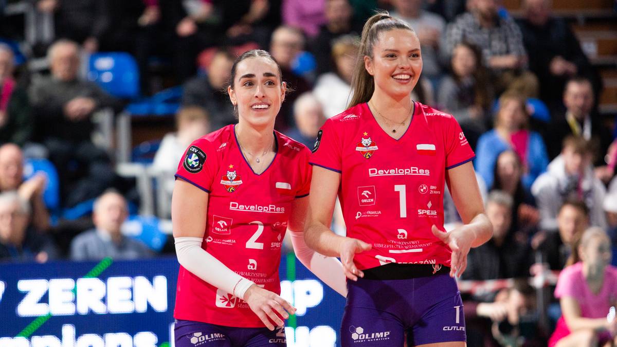 Dwie siatkarki w czerwonych strojach z numerami 1 i 2 na koszulkach.