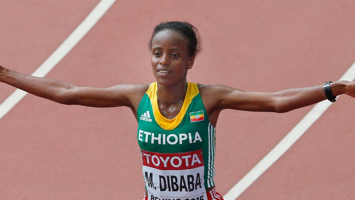 Lekkoatletka z Etiopii, Tirunesh Dibaba, z rękami rozłożonymi na boki w geście triumfu po przekroczeniu linii mety.