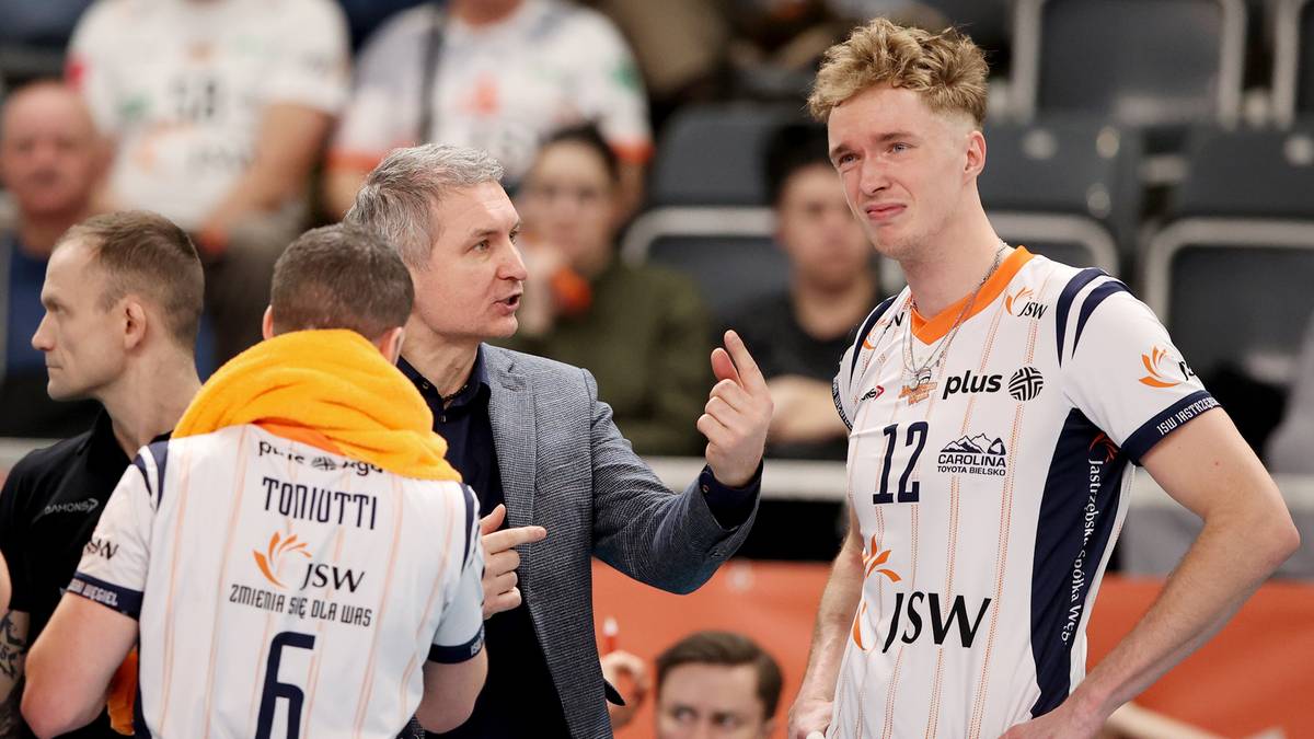 Siatkarze Jastrzębskiego Węgla podczas meczu, jeden zawodnik rozmawia z trenerem.