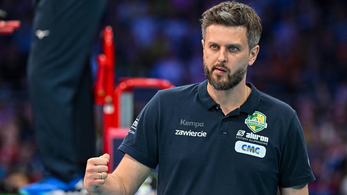 Trener drużyny siatkarskiej Aluron CMC Warta, mężczyzna z zarostem i w koszulce polo, zaciśniętą pięścią w geście triumfu.