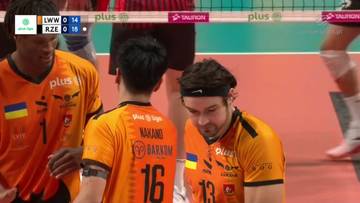 Siatkarze w pomarańczowych koszulkach dyskutują podczas meczu. Na koszulkach widać napisy "NAKANO" i "BARKOM" oraz numery "16" i "13".