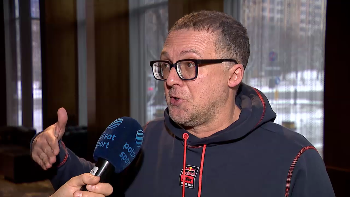 Mężczyzna w okularach w bluzie z kapturem udziela wywiadu.