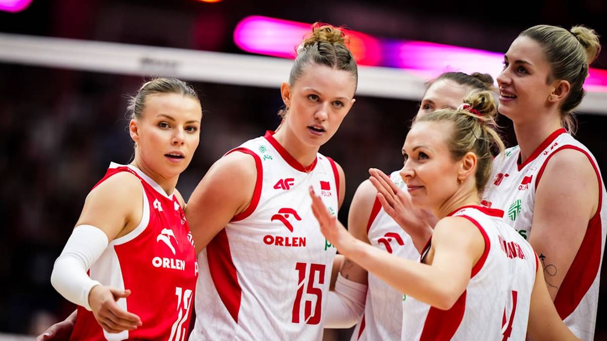 Grupa siatkarek w biało-czerwonych strojach reprezentacji Polski, niektóre mówią do siebie, inne patrzą w dal. Mają skupione miny.