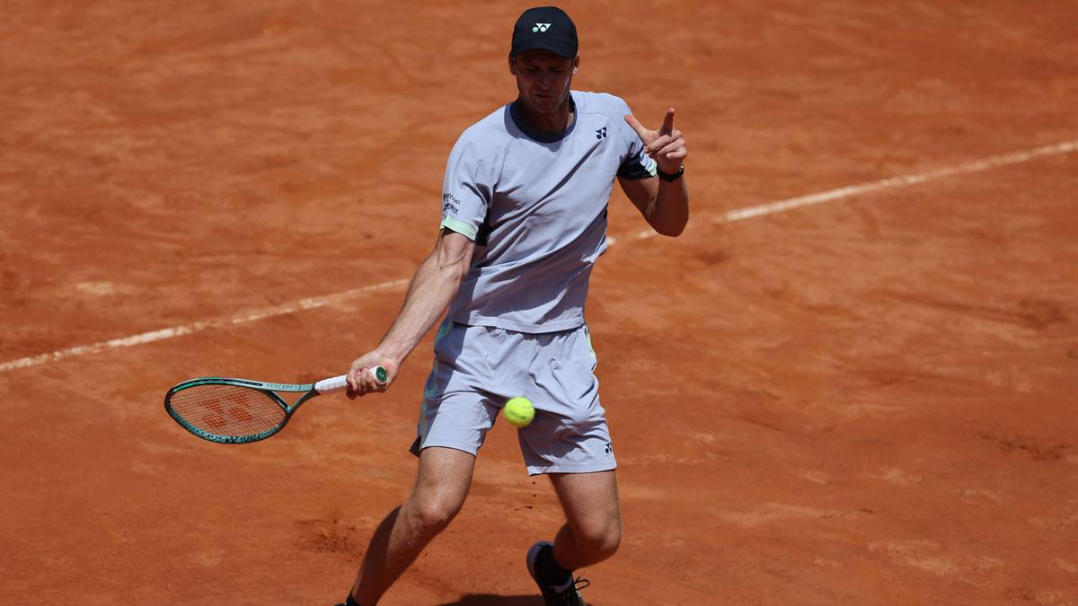 Hubert Hurkacz w szarym stroju tenisowym z rakietą w ręku na ziemnej nawierzchni kortu podczas meczu na Roland Garros.