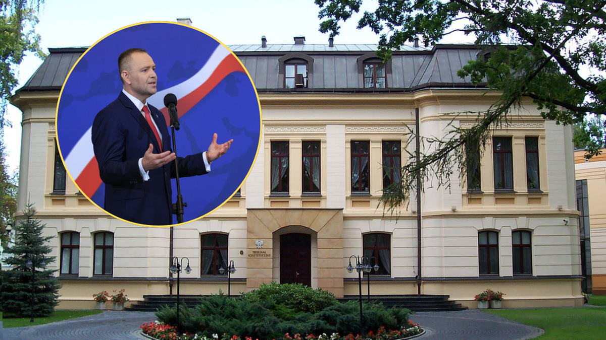 Mężczyzna w garniturze przemawia przy m&oacute;wnicy, w tle fasada budynku.