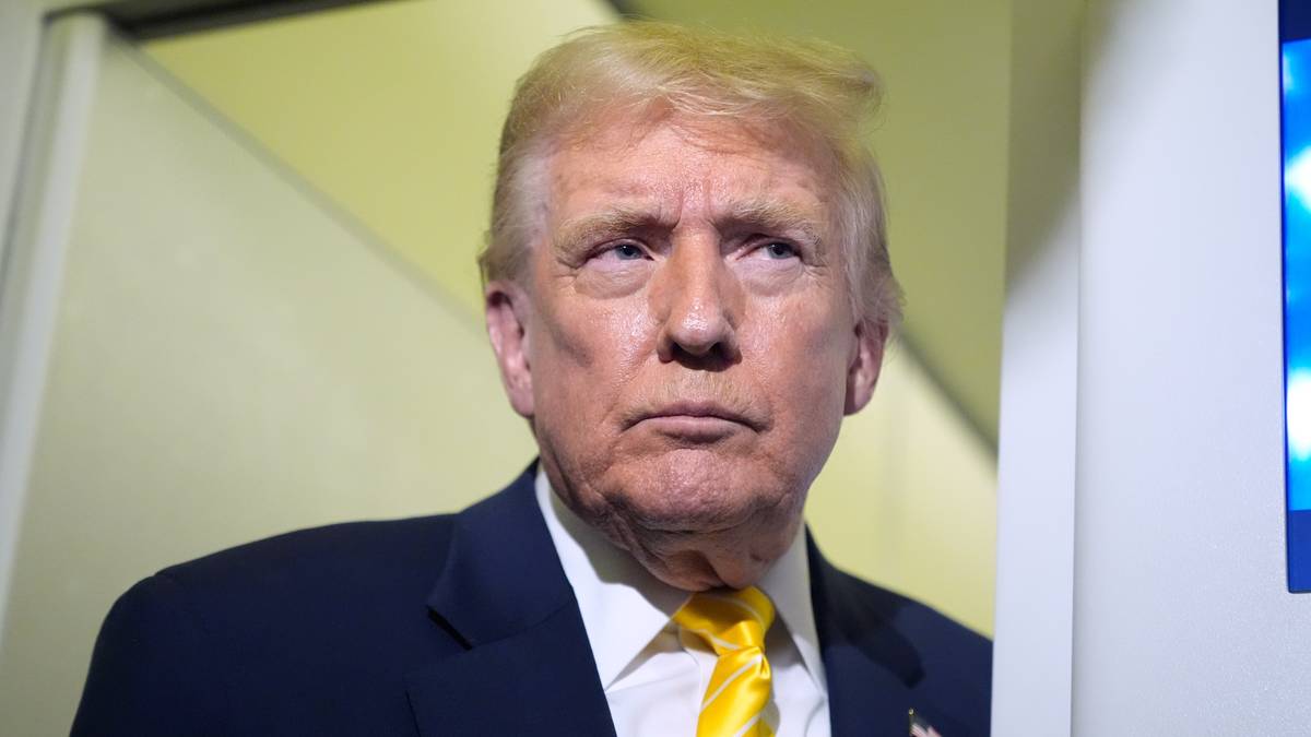 Donald Trump w granatowym garniturze i żółtym krawacie