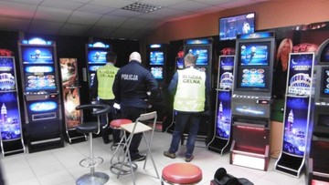 Salon z nielegalnymi automatami do gier hazardowych w fikcyjnym biurze podróży