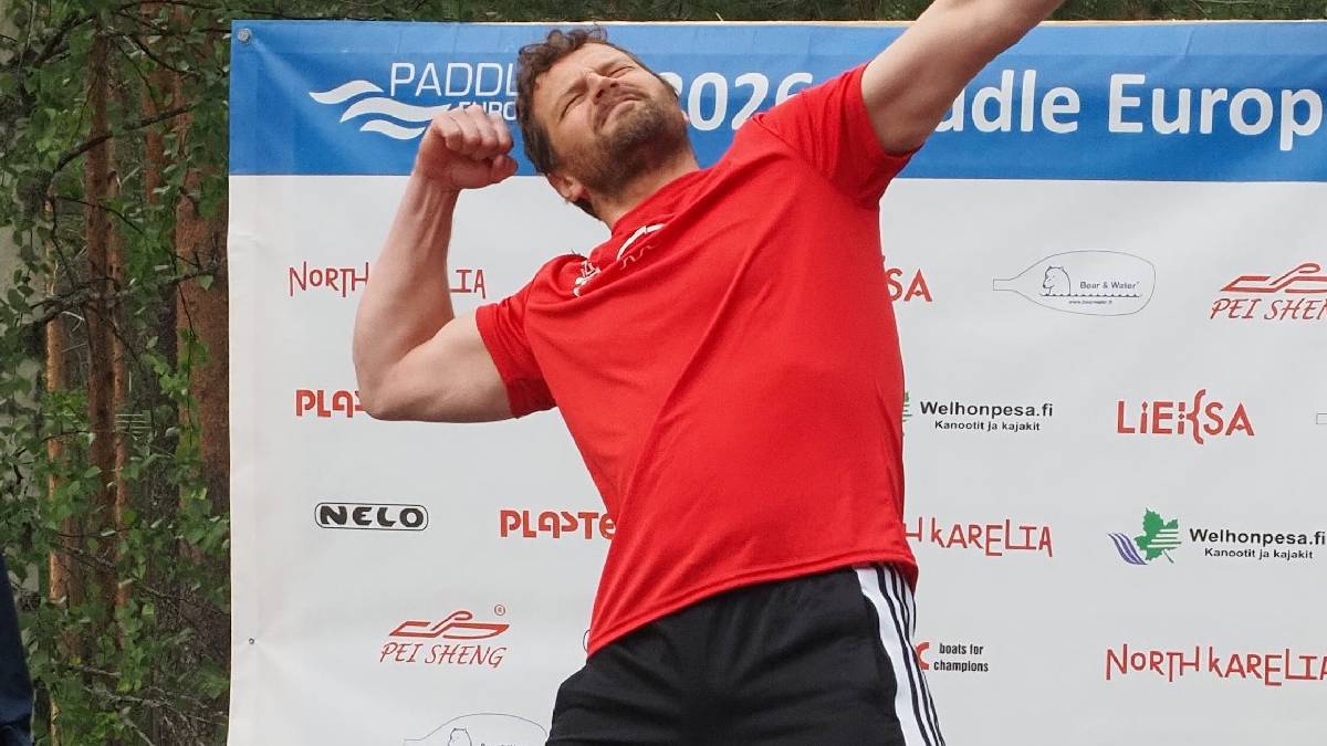 Mężczyzna w czerwonej koszulce napinający biceps.