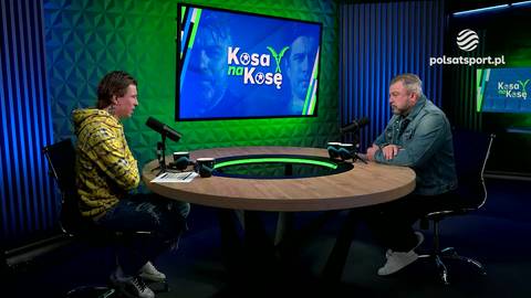 Dw&oacute;ch mężczyzn siedzi przy okrągłym stole w studiu telewizyjnym, przed nimi mikrofony i notatki. Na ekranie w tle widnieje napis "Kosa na Kosę".
