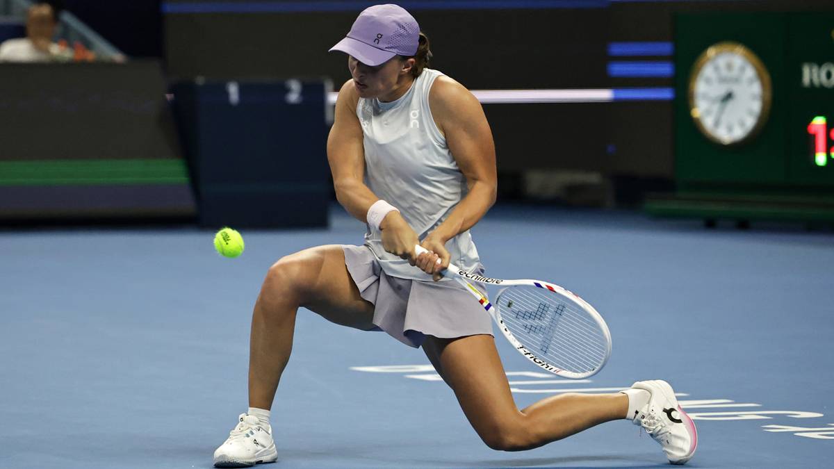 Iga Świątek podczas meczu tenisowego, wykonująca uderzenie.