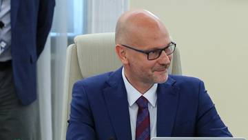 Premier Donald Tusk i Maciej Berek siedzą przy stole konferencyjnym.