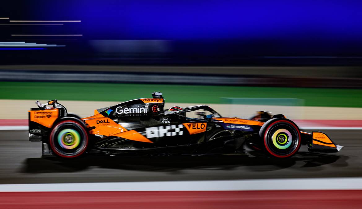 Bolid Formuły 1 zespołu McLaren podczas nocnego wyścigu, w ruchu.