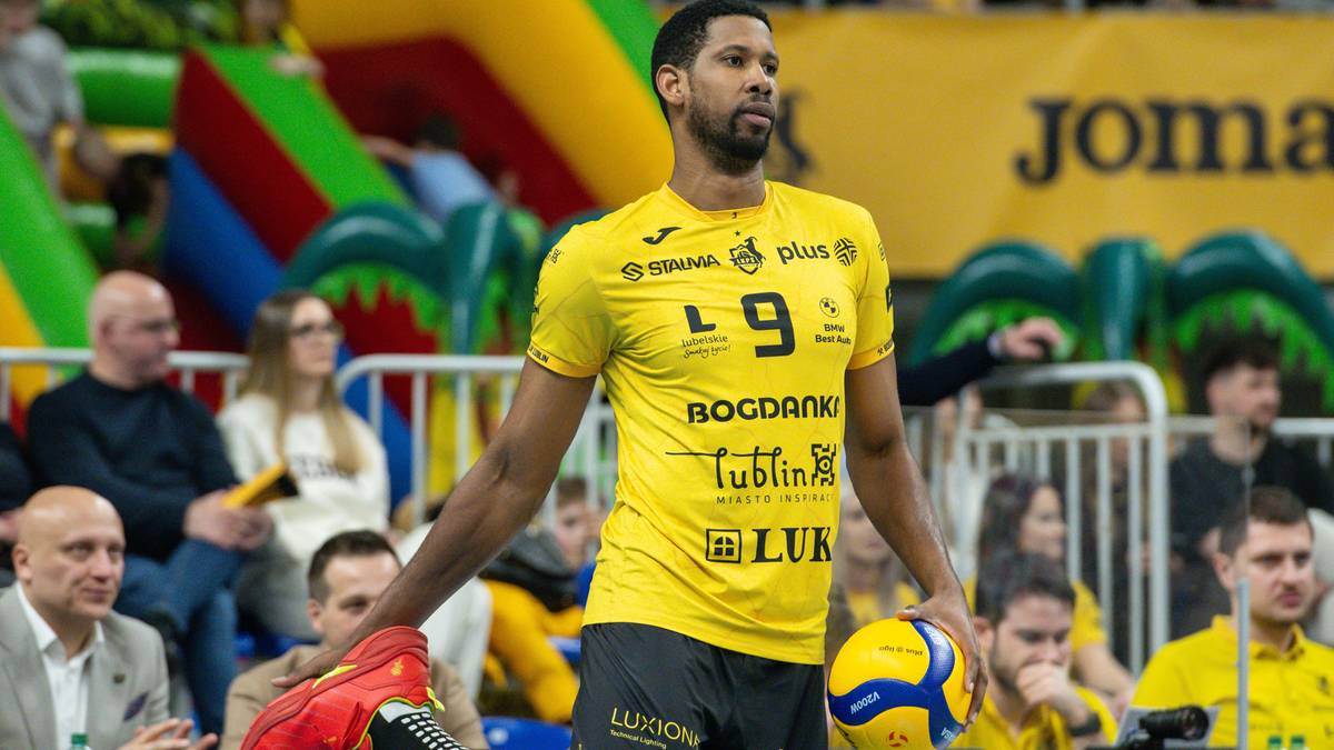 Siatkarz w żółtej koszulce Bogdanki LUK Lublin z piłką w ręku, gotowy do gry.