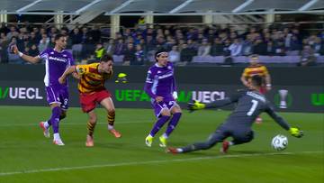 Piłkarz Jagiellonii Białystok Bartosz Mazurek strzela gola w meczu przeciwko Fiorentinie. Bramkarz Fiorentiny próbuje obronić strzał.