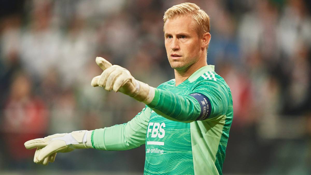 Kasper Schmeichel w zielonym stroju bramkarskim wskazuje palcem.