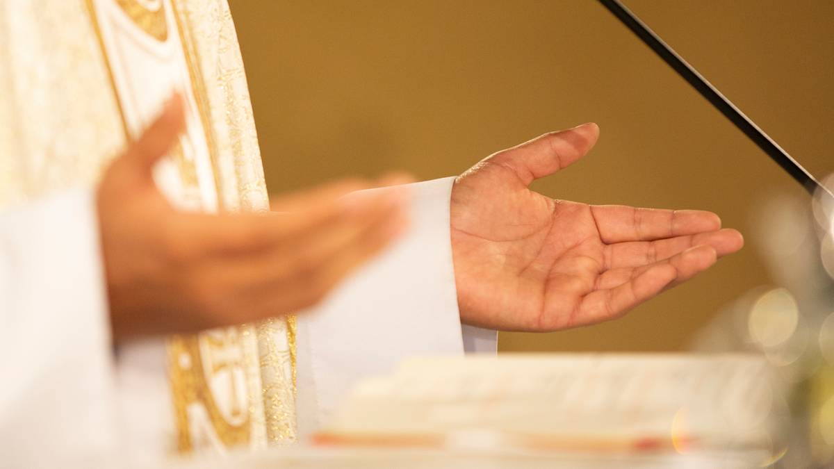 Dłonie księdza w białej albie podczas liturgii.