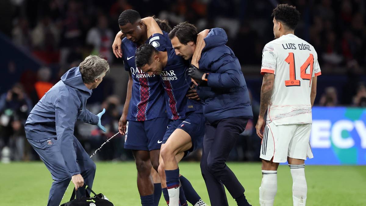 Piłkarze PSG otaczają kontuzjowanego kolegę, który jest prowadzony poza boisko.