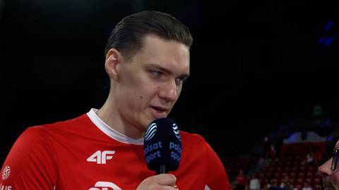 Bartłomiej Lemański w czerwonej koszulce sportowej udziela wywiadu, trzymając mikrofon z logo Polsat Sport.