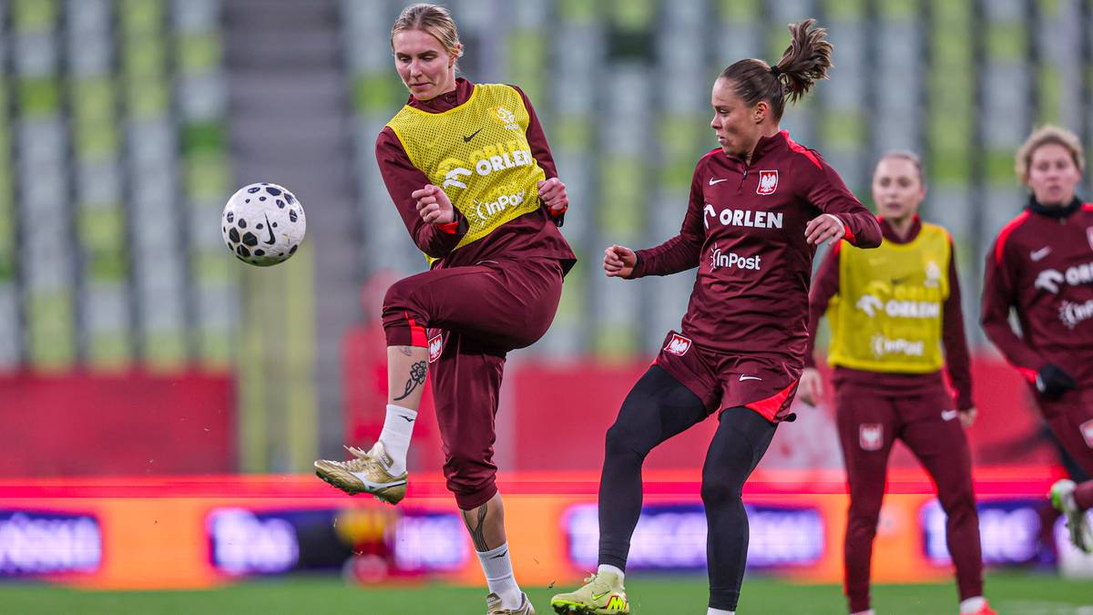 Dwie piłkarki w bordo-bordowych strojach na boisku piłkarskim.