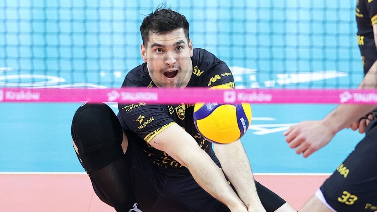 Siatkarz Mikołaj Sawicki w akcji, z piłką w rękach, podczas meczu.