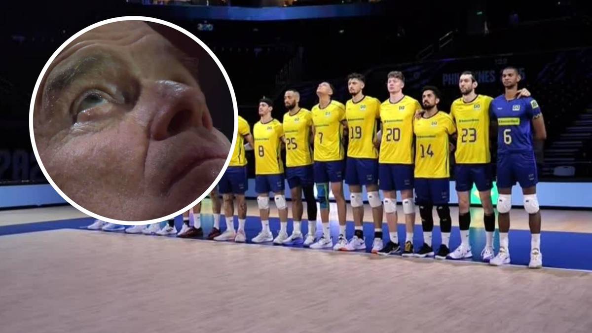 Zbliżenie na twarz starszego mężczyzny z niedowierzaniem w oczach, obok stoi jedenastu mężczyzn w strojach sportowych reprezentacji Brazylii.