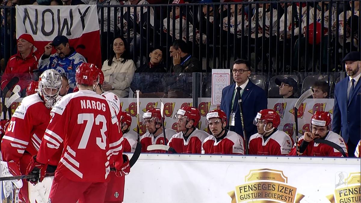 Drużyna hokejowa w czerwonych strojach z białymi numerami na plecach, częściowo widoczna twarz jednego z zawodników z numerem 73 na koszulce.