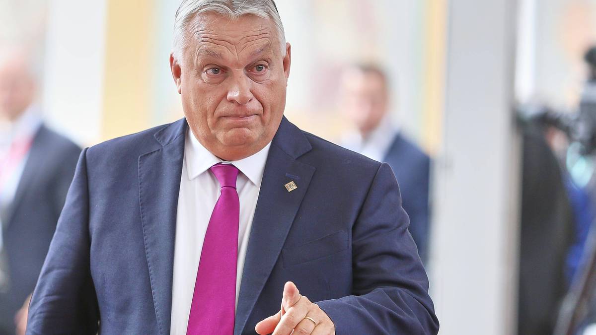 Viktor Orban, premier Węgier, w garniturze i krawacie, wskazuje palcem w stronę widza.