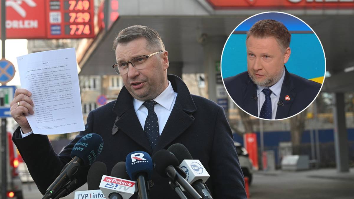 Mężczyzna w garniturze trzymający dokument, otoczony przez mikrofony, na tle stacji paliw Orlen. W prawym g&oacute;rnym rogu zdjęcie innego mężczyzny.