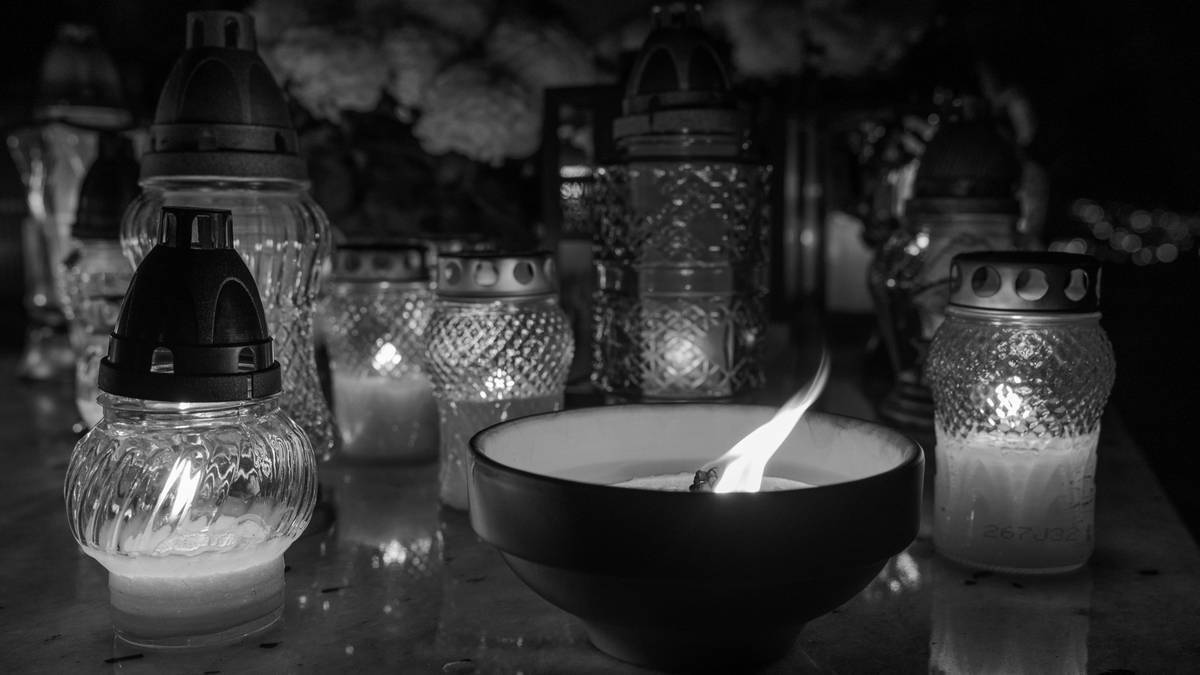 Zapalone znicze i świece w szklanych lampionach.