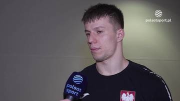 Młody mężczyzna, siatkarz, udziela wywiadu z mikrofonem Polsat Sport, w tle logo Polsat Sport.