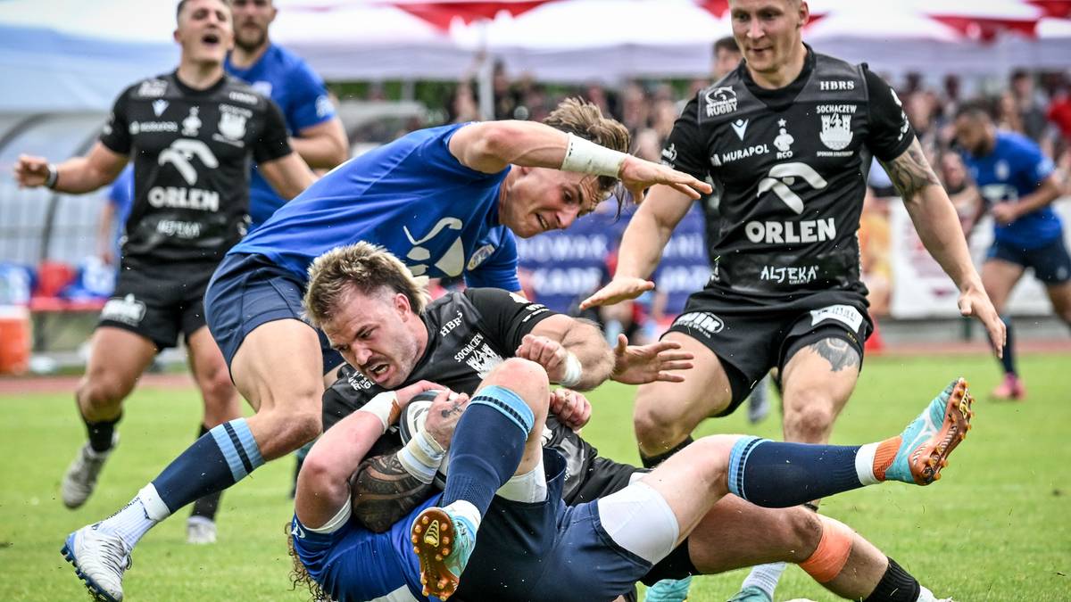Gracze rugby walczący o piłkę na boisku.