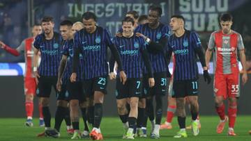 Grupa piłkarzy Interu Mediolan w niebiesko-czarnych strojach idzie po boisku.