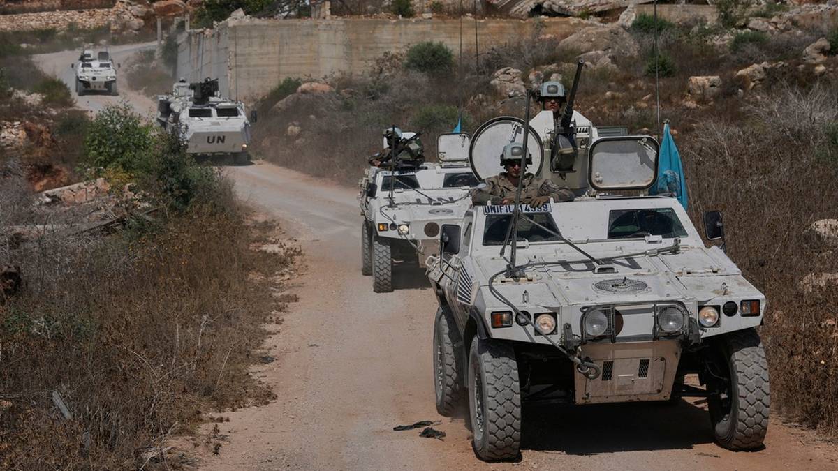 Konw&oacute;j pojazd&oacute;w wojskowych poruszający się po drodze w terenie g&oacute;rzystym.