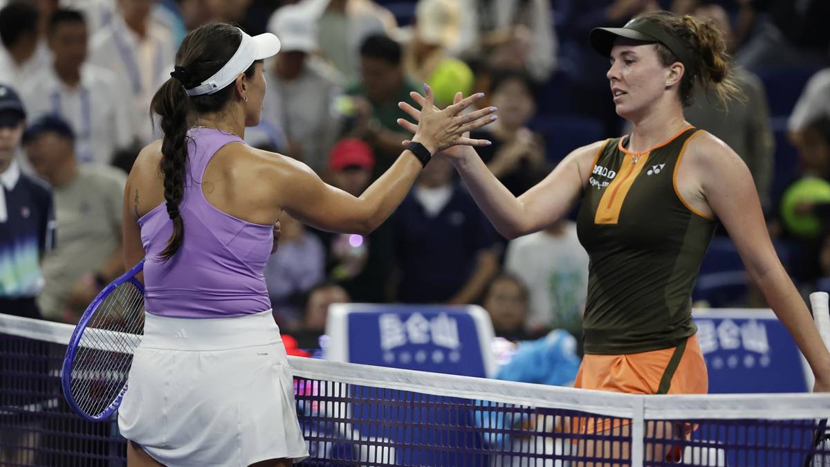 Dwie tenisistki podają sobie ręce nad siatką po meczu.
