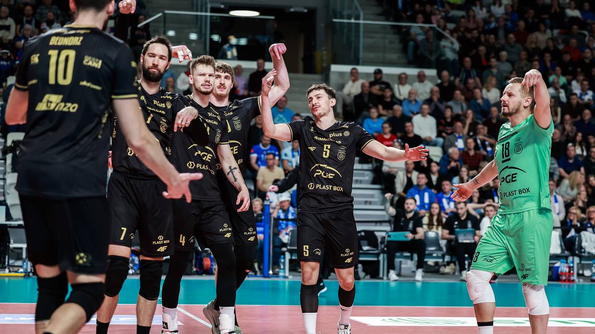 Siatkarze Projektu Warszawa w czarnych strojach i Jastrzębskiego Węgla w zielonych strojach podczas meczu na boisku siatkarskim.