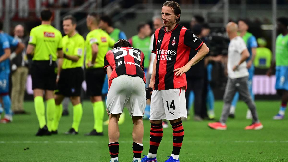 Dw&oacute;ch piłkarzy AC Milan na boisku po przegranym meczu, jeden stoi z rękami na biodrach, drugi pochyla się.