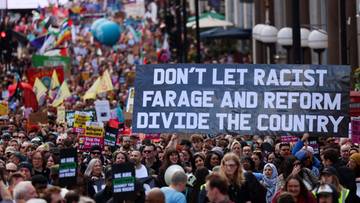 Transparent z napisem "DON'T LET RACIST FARAGE AND REFORM DIVIDE THE COUNTRY" niesiony przez tłum ludzi podczas demonstracji w Londynie.
