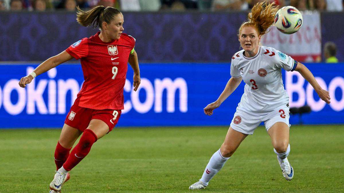 Piłkarka w czerwonej koszulce Polski walczy o piłkę z zawodniczką w białej koszulce Danii.