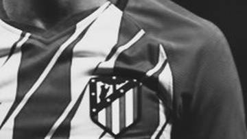 Fragment koszulki piłkarskiej Atletico Madryt z widocznym herbem klubu.