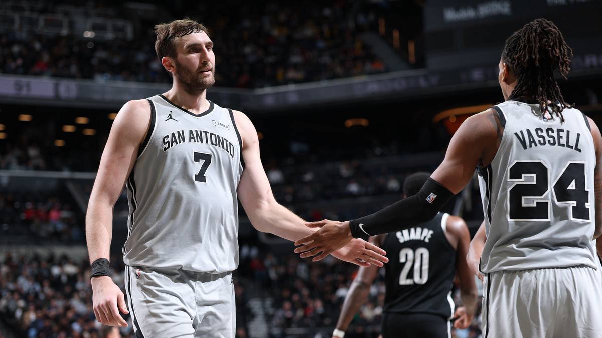 Dw&oacute;ch koszykarzy San Antonio Spurs, jeden z numerem 7, drugi z numerem 24, podaje sobie ręce.